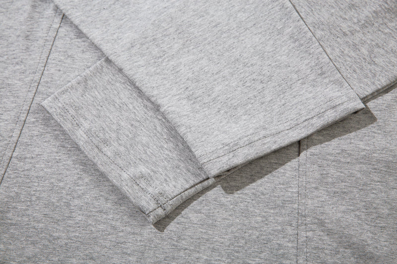 Close-up of the light gray sleeve cuff and chest seam on the long sleeve tee