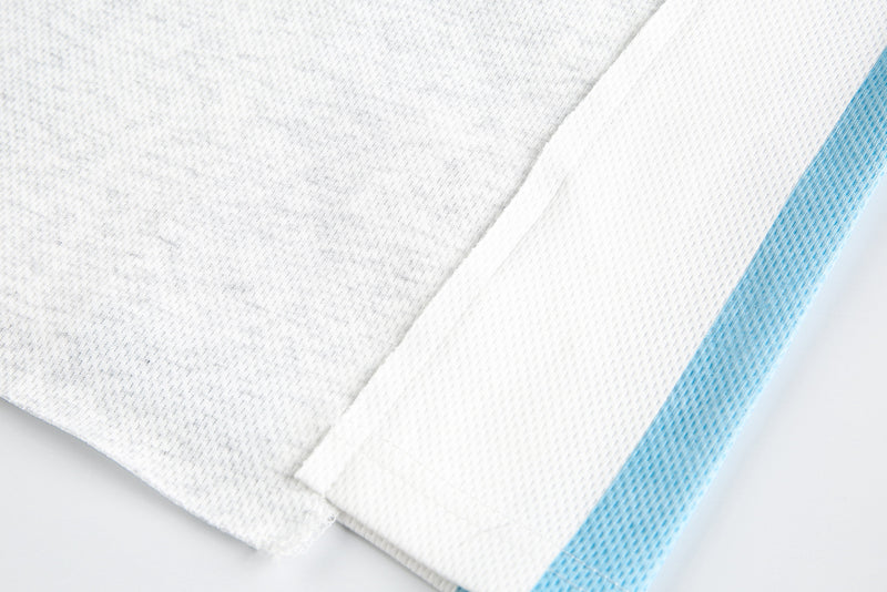 Close-up of hem and sleeve edge on off-white and light blue long sleeve tee