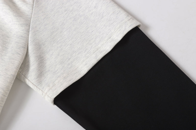 Sleeve close-up showing light gray cuff over black long sleeve underlayer