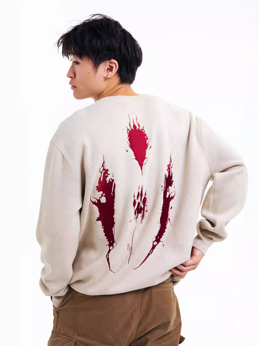 A person with short black hair, seen in profile, wears Seakoff's Princess Mononoke Inspired Beige Sweatshirt featuring a wolf spirit mask and red claw design. Styled with brown pants against a plain white background, they exude subtle eco-warrior vibes.