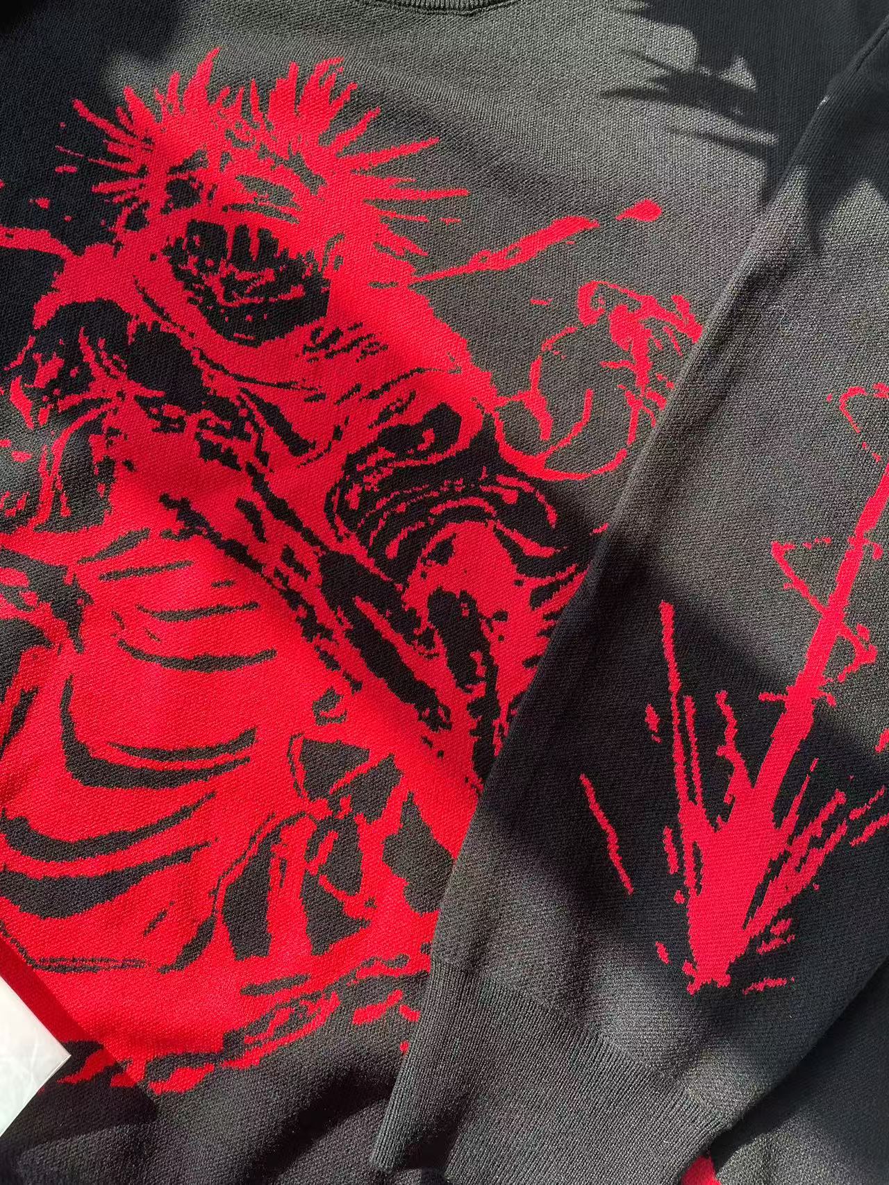 The Jujutsu Kaisen Inspired Black Sweatshirt by the brand features a vibrant red cursed energy design that sharply contrasts with the dark fabric, capturing streetwear style and anime&