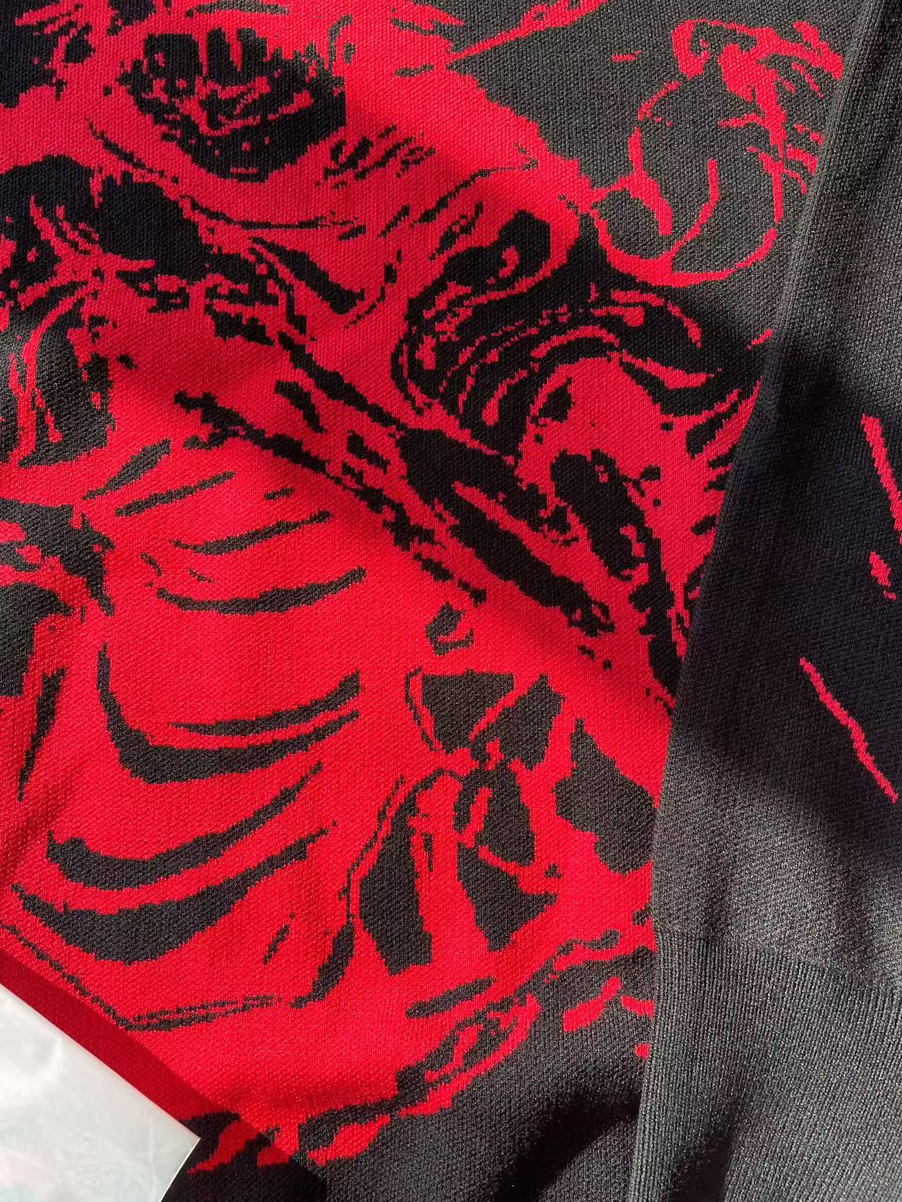 Close-up of the Jujutsu Kaisen Inspired Black Sweatshirt - Red Cursed Energy Design, featuring an abstract red and black pattern reminiscent of Jujutsu Kaisen&