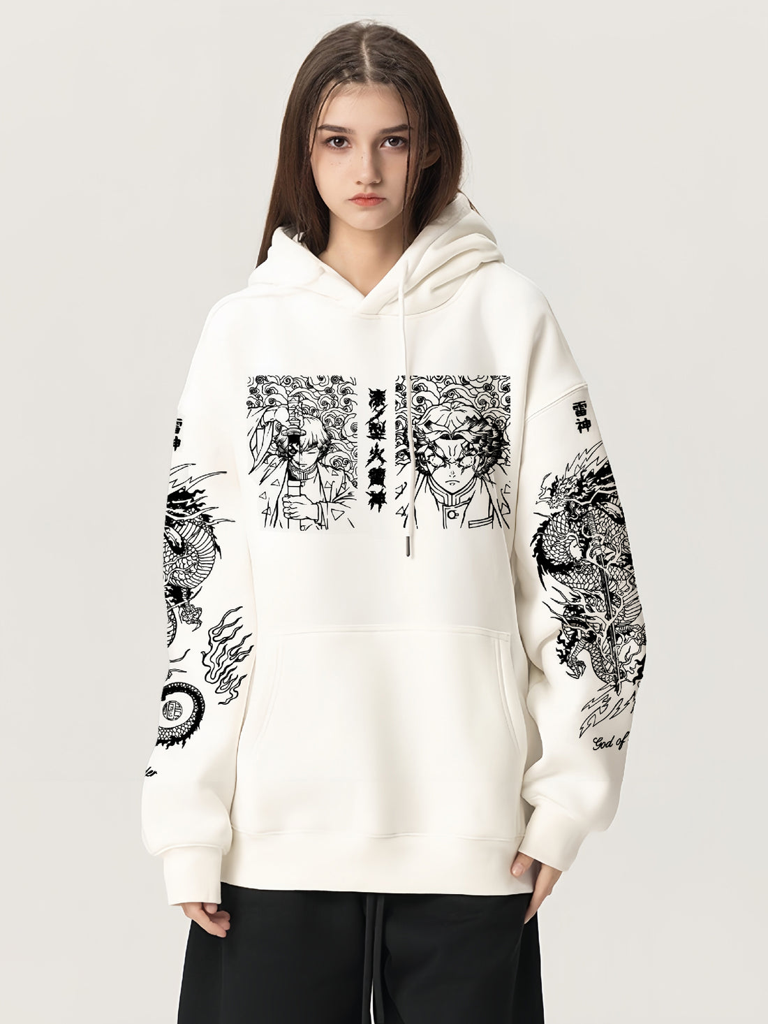 Wearing the cream-colored Zenitsu Agatsuma-Inspired &quot;Thunder God&quot; Hoodie by Demon Slayer, featuring anime-style illustrations and dragon designs in black ink on the front and sleeves, this person embodies anime streetwear. They stand confidently with long hair against a plain backdrop.