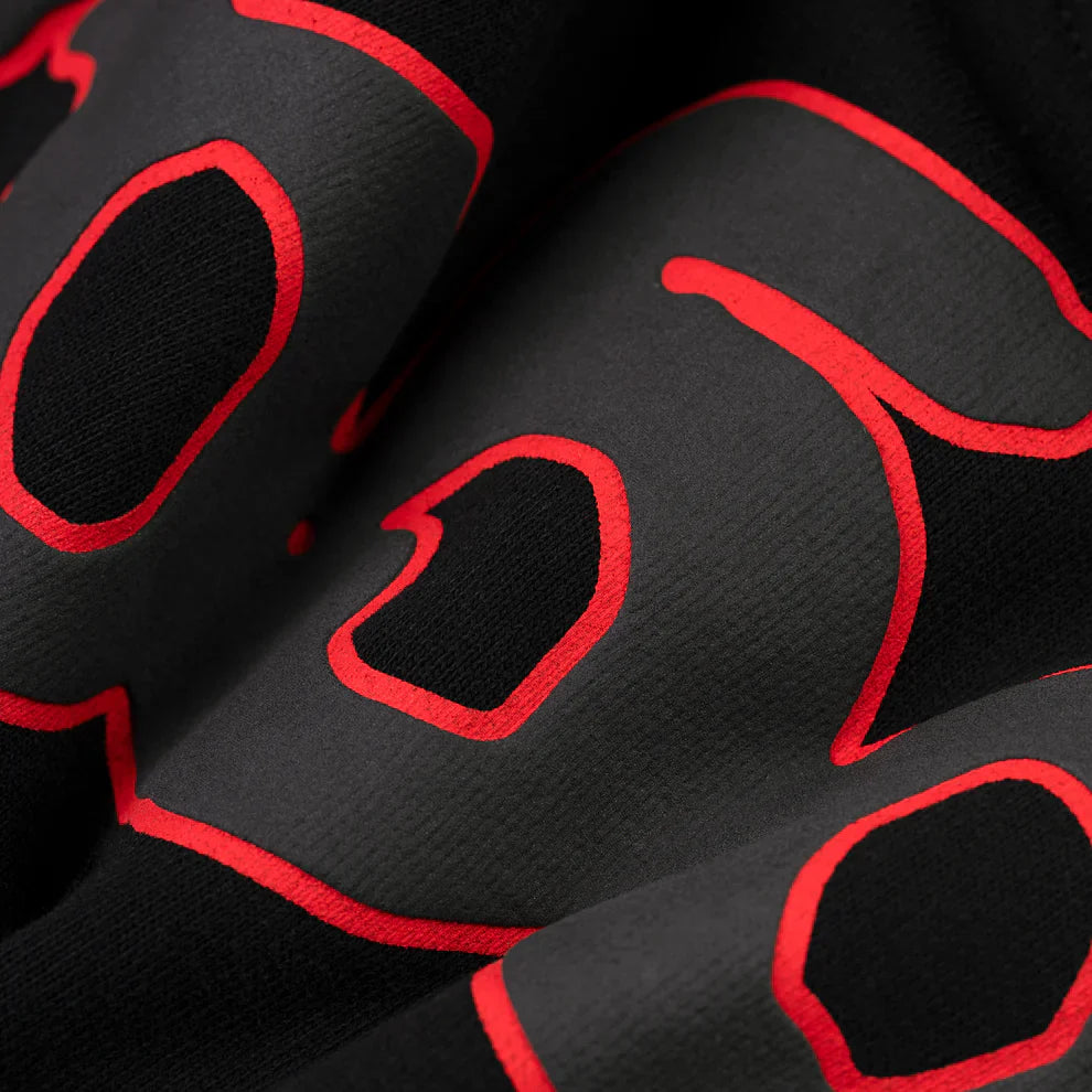 Close-up of the Sp5der 440GSM Heavyweight Star Hoodie – Black & Grey Oversized Streetwear Pullover shows soft, heavyweight fleece with bold gray letters outlined in red, giving the hoodie a modern, abstract street style.