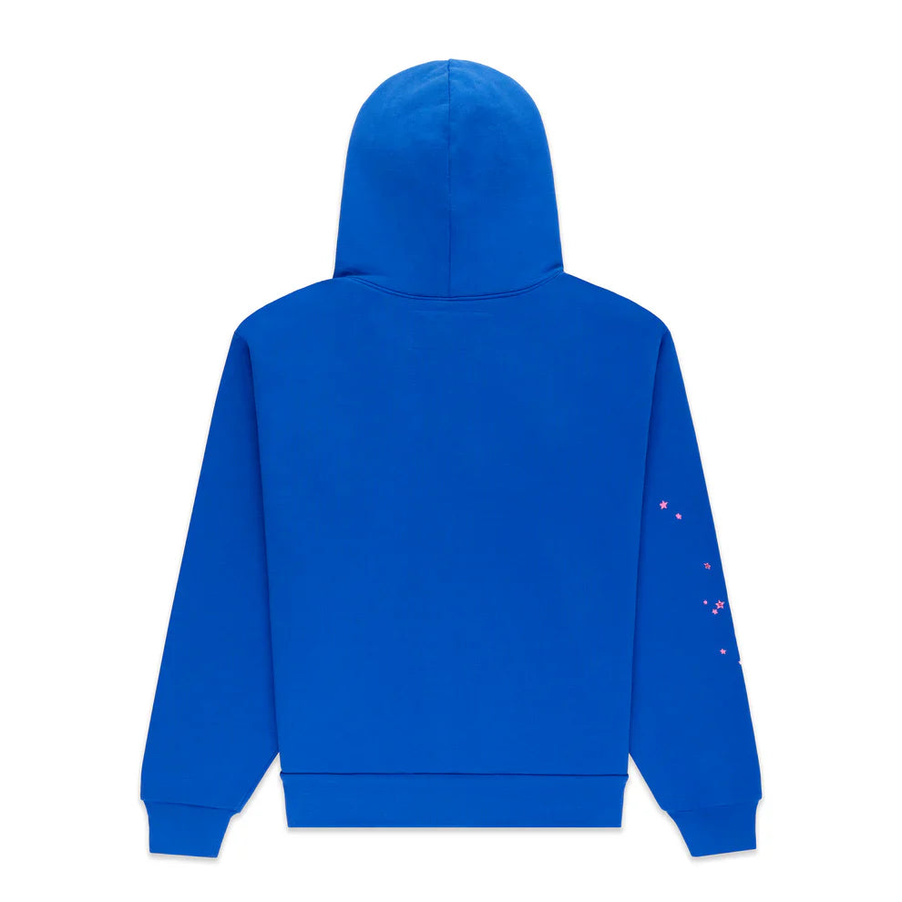 The Sp5der “555” Hoodie in Royal Blue is a 440GSM heavyweight streetwear pullover shown from the back, with a plain design and subtle pink star-like accents on the right sleeve. The hood is up and there are no visible logos or patterns on the main body.