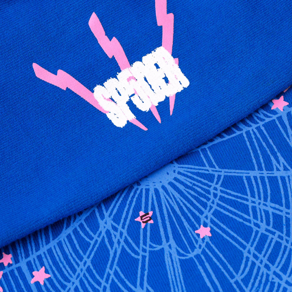 Close-up of the Sp5der “555” Hoodie – Royal Blue, a 440GSM heavyweight streetwear pullover featuring white SPIDER text, pink lightning bolts, and web graphics with stars on premium cotton fleece.