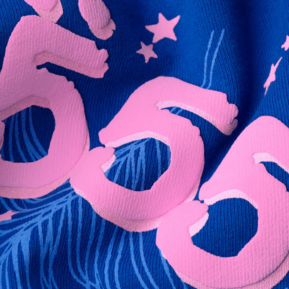 Close-up of heavyweight 440GSM fleece in royal blue, featuring large pink “555” numbers, small stars, and feather-like designs—signature details of the Sp5der “555” Hoodie streetwear pullover.