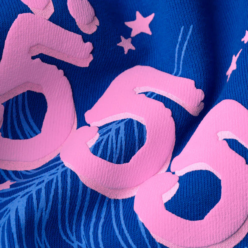 Close-up of heavyweight 440GSM fleece in royal blue, featuring large pink “555” numbers, small stars, and feather-like designs—signature details of the Sp5der “555” Hoodie streetwear pullover.
