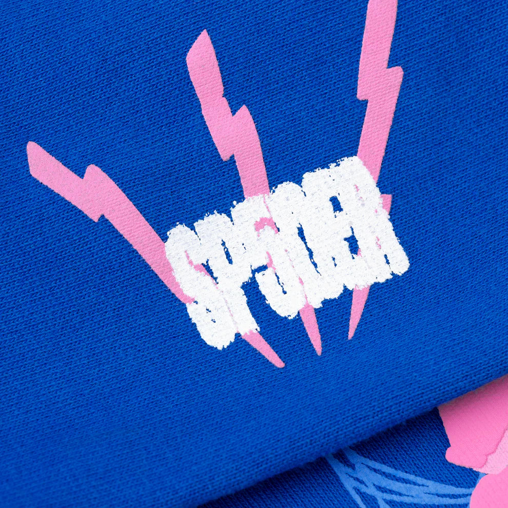 A close-up of royal blue fabric with pink lightning bolts and bold, white, distressed "SPENCER" text highlights the streetwear feel and heavyweight 440GSM cotton fleece style of the Sp5der “555” Hoodie – Royal Blue Spider Web Pullover.