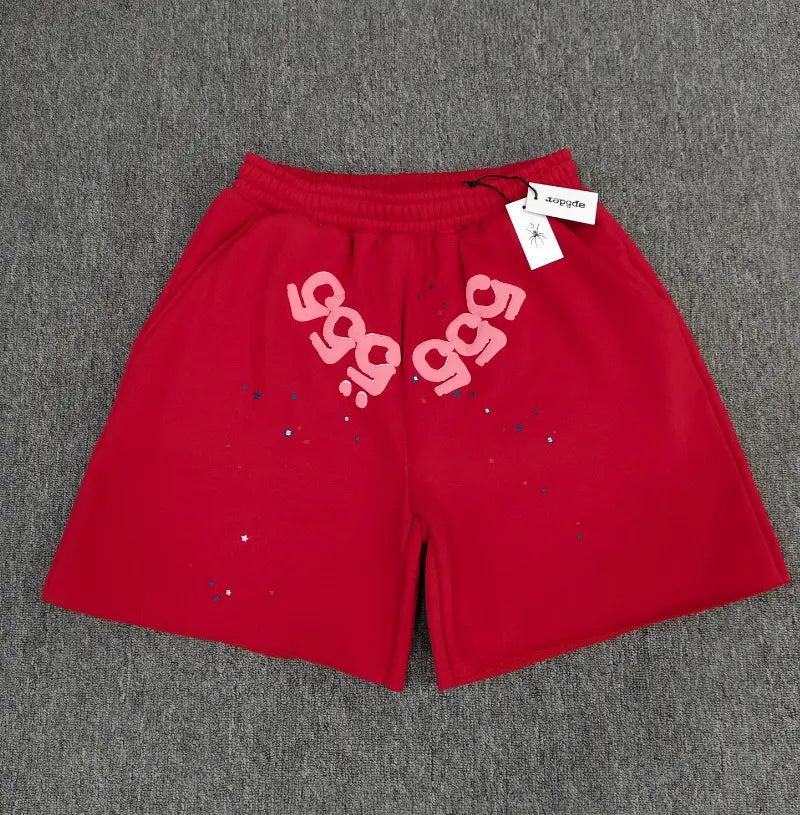 Red Sp5der jogger shorts with pink 555 letter print and star splatter on the front