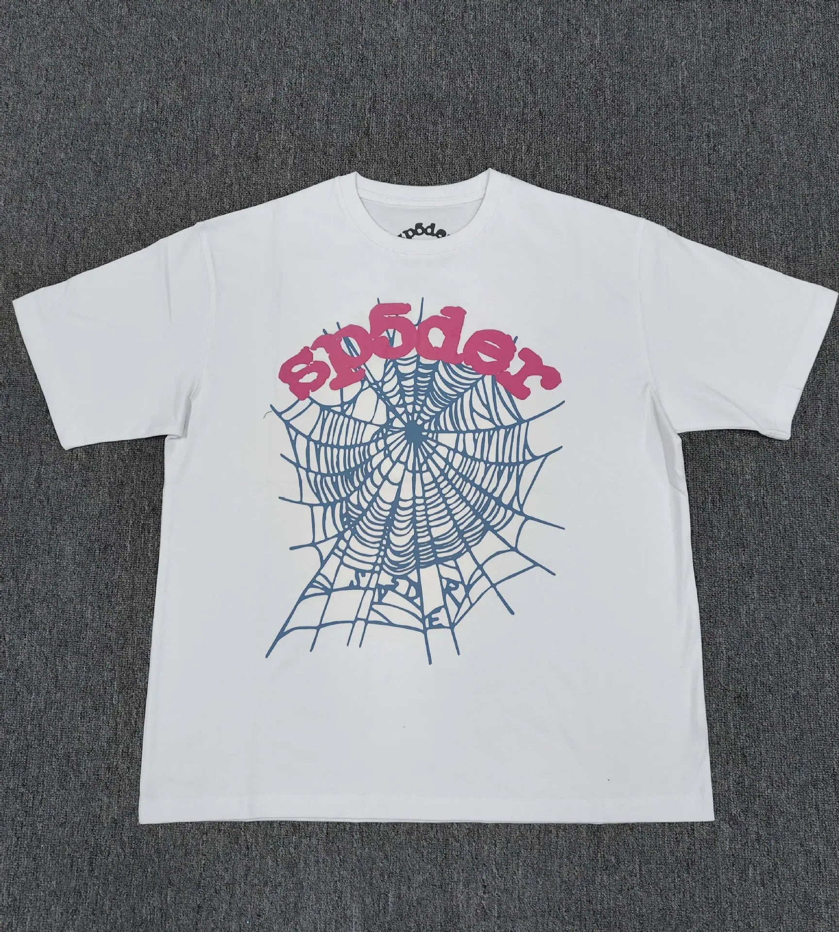 White Sp5der t-shirt with blue spider web graphic and pink sp5der lettering on the front
