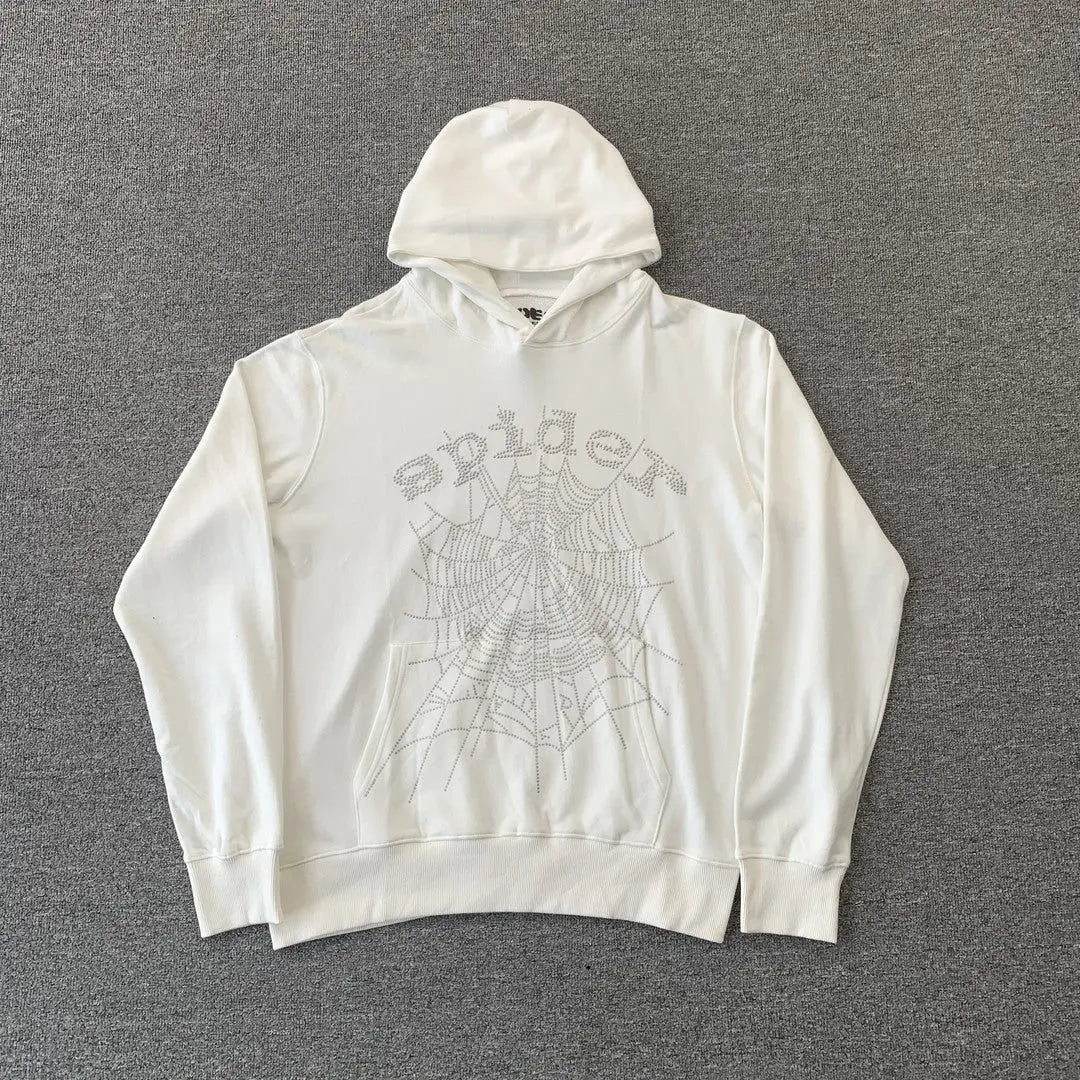 The White Sp5der Crystal Web Hoodie 440GSM features a bold rhinestone spiderweb and "spider" in stylized letters on the chest, making it a standout luxury streetwear piece.