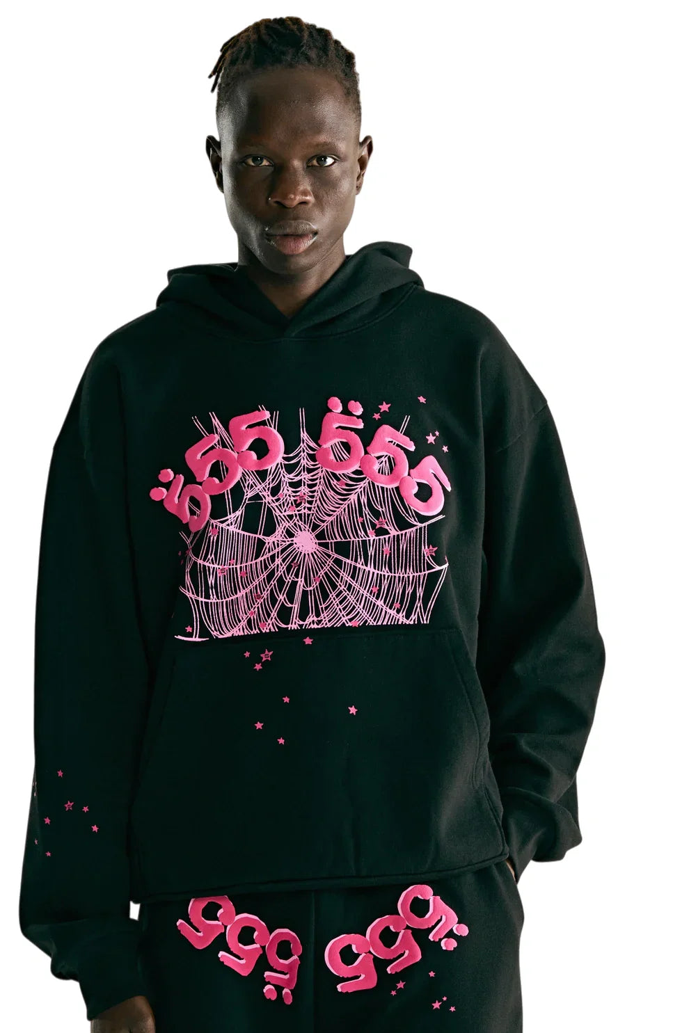 Wearing the Sp5der 555 Hoodie – Black & Pink Web 440GSM Heavyweight Streetwear Pullover with bright pink stylized text and a spiderweb graphic, paired with matching black pants featuring pink text, set against a white background.