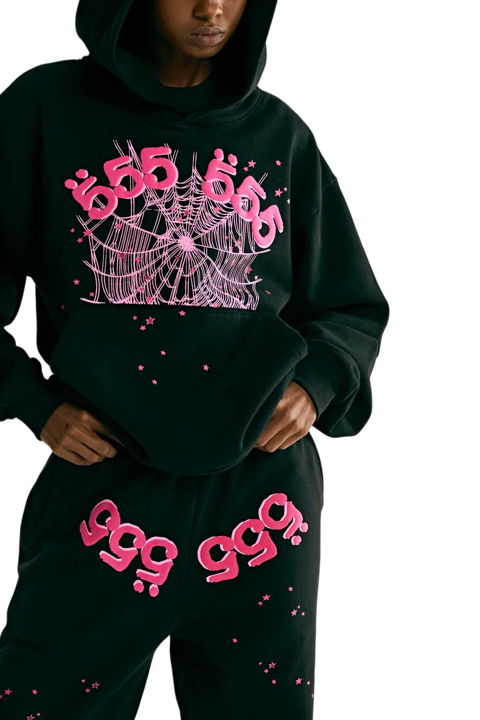 A person wearing the Sp5der 555 Hoodie – Black & Pink Web 440GSM Heavyweight Streetwear Pullover and matching sweatpants with pink web and number graphics—ideal for bold luxury streetwear and Y2K fashion fans.