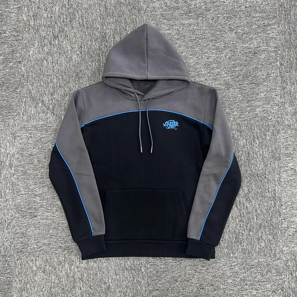 Syna World black and grey color block pullover hoodie with blue piping and chest embroidery laid flat