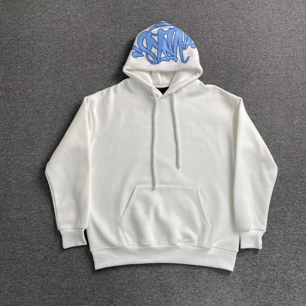 White pullover hoodie with blue graffiti letter graphic on the hood, laid flat on a grey surface