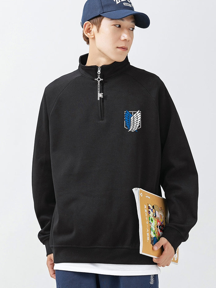 A person wearing the Limited Edition Attack on Titan Half-Zip Sweatshirt featuring Eren’s Key zipper and the Scout Regiment logo, a blue cap, holding a book, and looking to the side.